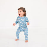 Child wearing a blue pajama with airplane pattern on a white background
